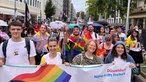 Personen mit Bannern und Regenbogenfahnen beim CSD in Düsseldorf