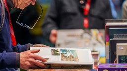 Mann blättert in einem Buch