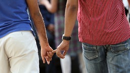 Zwei Männer halten sich an den Händen