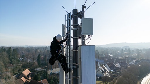 Techniker der Deutschen Telekom führen an einem Mobilfunkmast eine Qualitätsüberprüfung durch