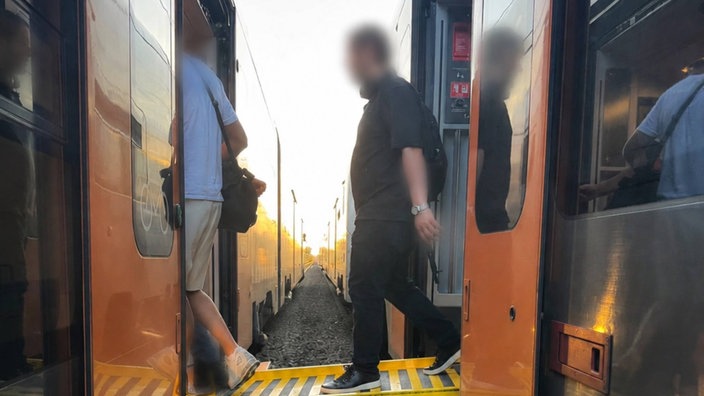 Passagiere steigen über eine Brücke in den Ersatzzug um