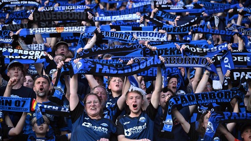 Fans des SC Paderborn halten beim Spiel Schals nach oben