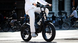 Ein Mann fährt mit einem Fatbike durch das Zentrum von Amsterdam