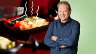 Das Bild zeigt Björn Freitag im Hintergrund ist ein Raclette-Pfännchen zu sehen. 