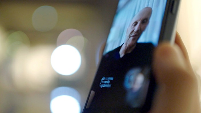 Ein Smartphone, über das Staatsanwalt Andreas May per Videoanruf zugeschaltet ist.