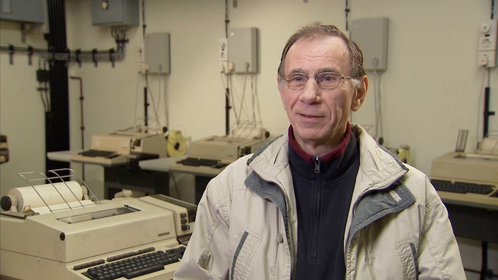 Claus Roehling vor einer Schreibmaschine und Fernschreibern