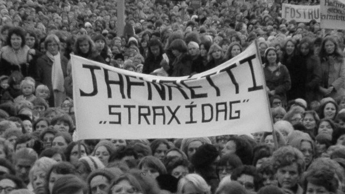 Viele Frauen halten auf einer Demo ein Banner hoch. 