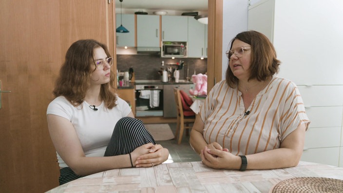 Zwei Frauen, Ilona und Svea, sitzen am Tisch und sprechen miteinander