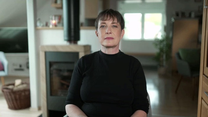 Porträt einer Frau mit dunklen kurzen Haaren, die nach vorn in die Kamera schaut