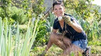 Dajana Schmitt sitzt in einem Gemüsebeet. 