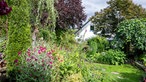 Blick auf Garten und Haus im Hintergrund von Peter Mecklenburg