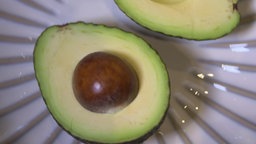 Eine aufgeschnittene Avocado auf einem Teller