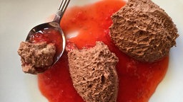 Zwei Nocken Schoko-Mousse auf rotem Spiegel