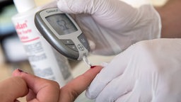 Nahaufnahme der Durchführung eines Blutzucker-Tests mit modernem Gerät