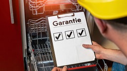Mann blickt auf einen Bogen mit eienr Garantie-Checkliste