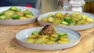 Hackbällchen mit Speck auf lauwarmem Kartoffelgurkensalat