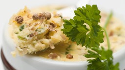 Gewürzbutter in einer Schale, garniert mit einem Blatt Petersilie