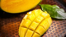 Auf einem Teller liegt eine aufgeschnittene Mango
