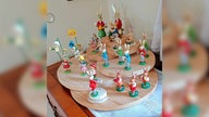Mehrere kleine Osterhasen aus Holz stehen in einem Zimmer.