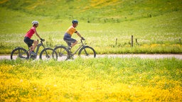 Paar, Mann und Frau auf Tour mit Fahrrädern, Trekkingbike, E-Bike