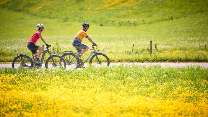 Paar, Mann und Frau auf Tour mit Fahrrädern, Trekkingbike, E-Bike