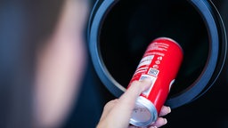 Eine Dose wird in einen Pfandautomat geschoben