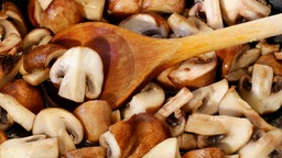Pilze werden in einer Pfanne angebraten