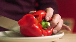 Rote Paprika wird geschnitten