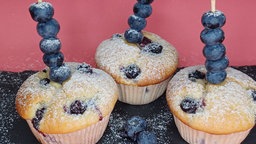 Auf dem Foto sind drei Blaubeermuffins zu sehen.