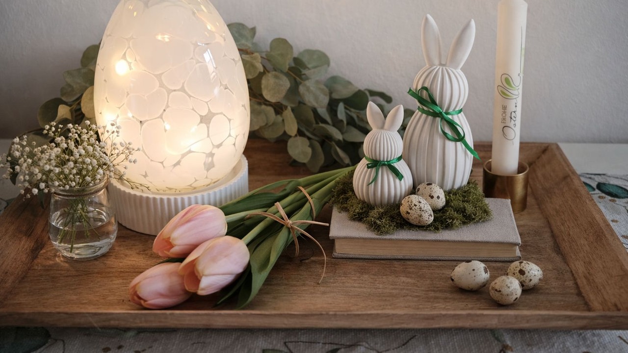 Osterdeko mit Leuchtei, Tulpen, Kerzen und Hasen