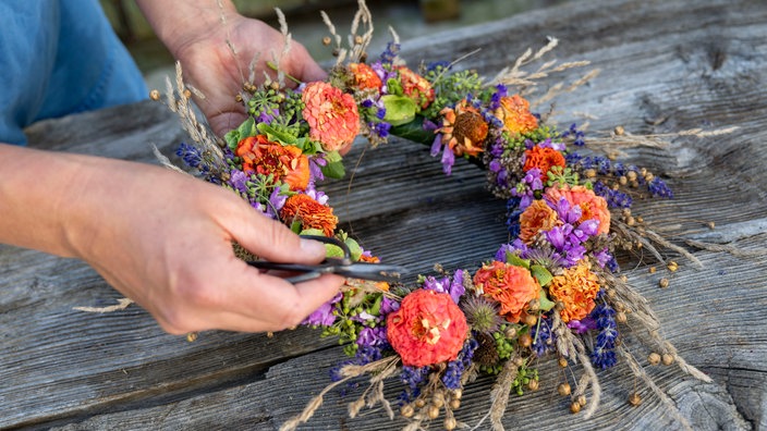 Anna Pröbstle bindet einen Blumenkranz. 