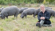 Annika Ahlers-Vincke mit Ibérico-Schweinen auf der Weide
