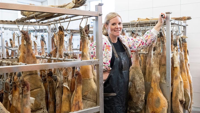 Annika Ahlers-Vincke in der Reifekammer mit vielen Schinken.