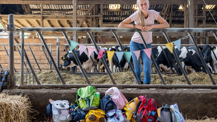 Marina Dickhoven im Stall, vor ihr eine Menge Kinderrucksäcke.