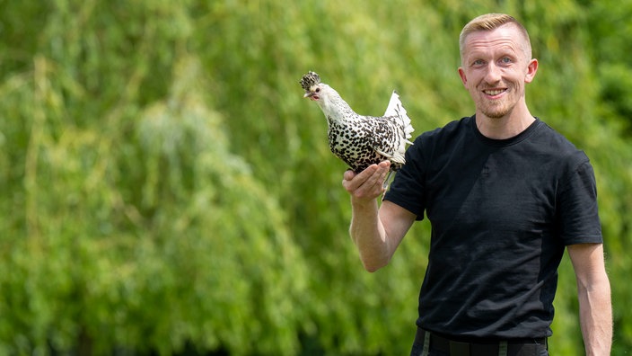Michael Peine mit einem Huhn. 