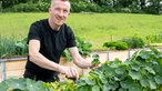 Michael Peine an einem Hochbeet. 