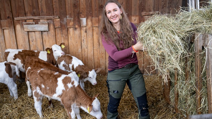 Verena Krimbacher versorgt die Kühe mit Stroh. 