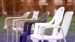 Vier verschiedene Gartenstühle aufgereiht.
