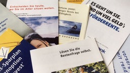Werbeprospekte für private Rentenversicherungen liegen übereinander. 