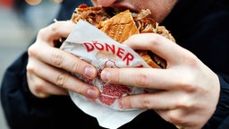 Ein Mann isst einen Döner
