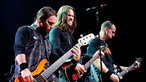 Drei Bandmitglieder von Alter Bridge spielen Bass und Gitarre auf der Bühne