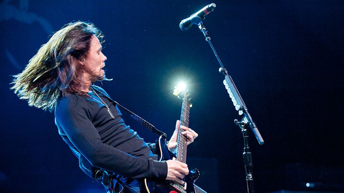 Bandmitglied von Alter Bridge spielt Gitarre und lehnt sich dabei nach hinten
