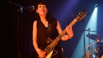 Gitarristin von Angelika Express spielt zufrieden einen Akkord auf ihrer Düsenberg Gitarre (teuer)