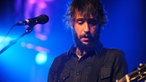Voller Konzentration blickt der Gitarrist auf die Saiten siener Gitarre
