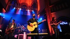 Die Band spielt gleichzeitig Akkustik und E-Gitarre auf der Bühne