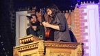 Sänger und Gitarrist stehen auf einer Kanzel und spielen 