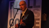 John Watts singt mit Gitarre bei Bootleg im Oktober 2005