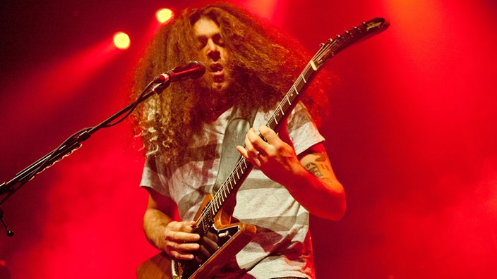 Coheed And Cambria Sänger beim gleichzeitigen Gitarre spielen