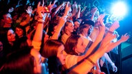 Die Fans stehen vor der Bühne und jubeln