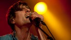 Navel-Sänger mit geschlossenen Augen am Mikrofon